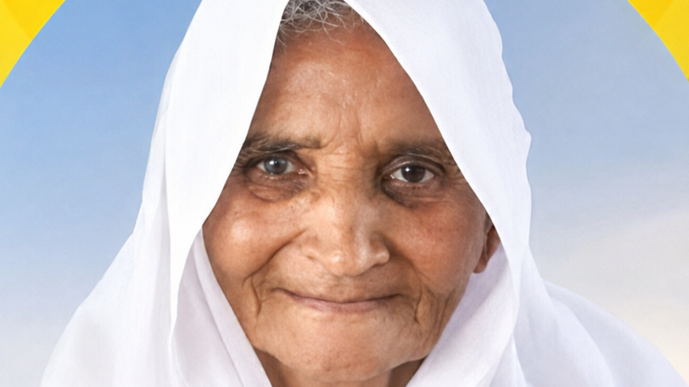 Close-up of an elderly woman in a white headscarf smiling softly against a blue sky background.