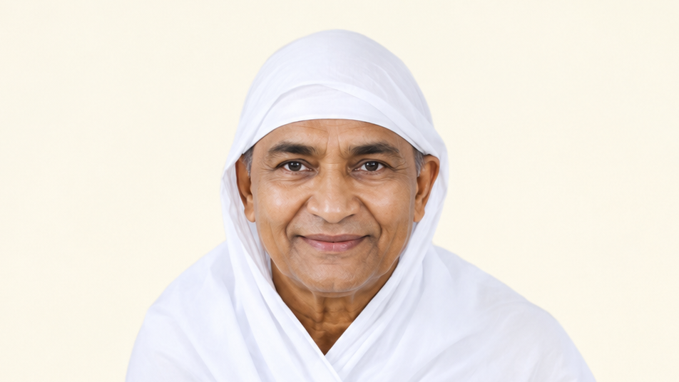 Smiling man in a white headscarf and robe looking at the camera.