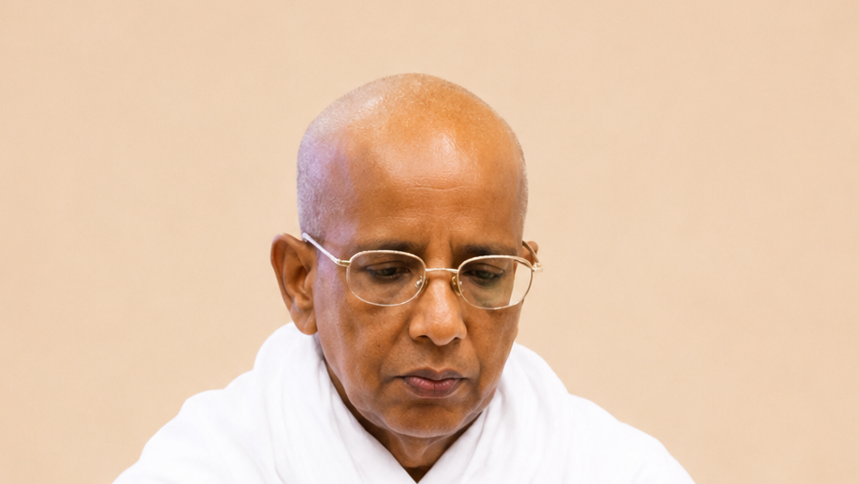 Close-up of a bald man wearing glasses and a white robe, looking downward in thought.