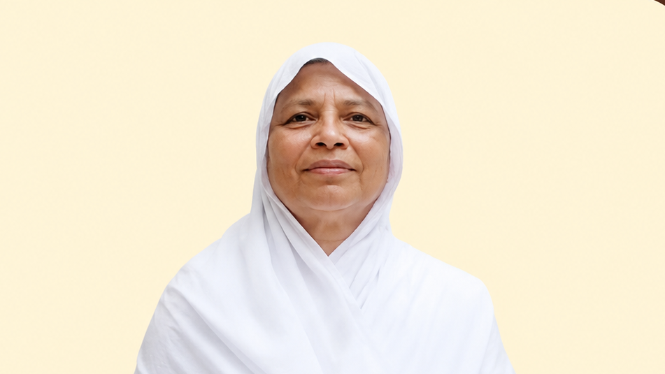 Portrait of a smiling woman wearing a white hijab against a pale yellow background.