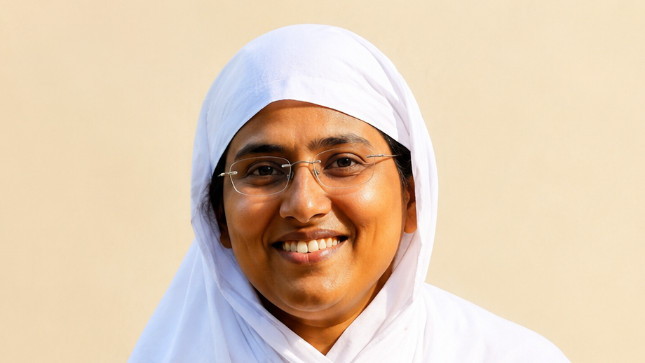 Portrait of a smiling woman wearing a white hijab and glasses against a beige background.