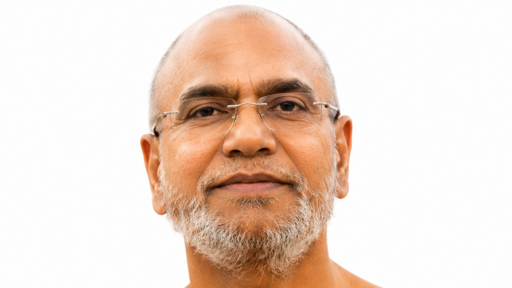 Close-up portrait of a middle-aged man with a grey beard and glasses, looking at the camera against a white background.